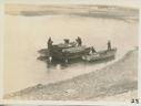 Image of Men working aboard small boats. Two boats carry smaller boats.